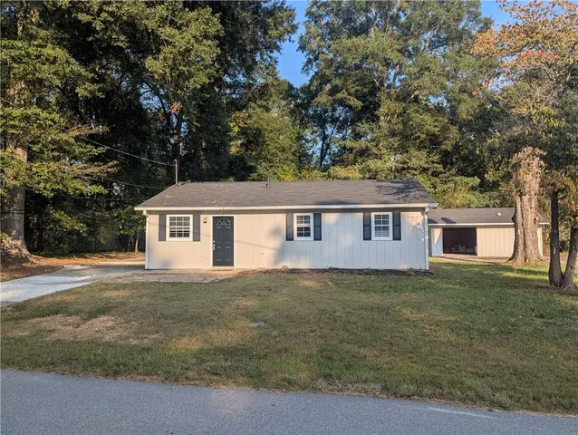 a view of a yard in front of a house with large tree