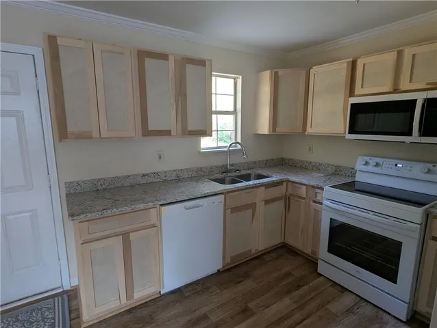 a view of a kitchen with a refrigerator a stove top oven and cabinets