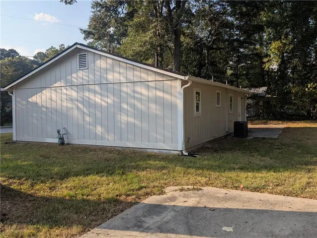 a white house covered with tall trees