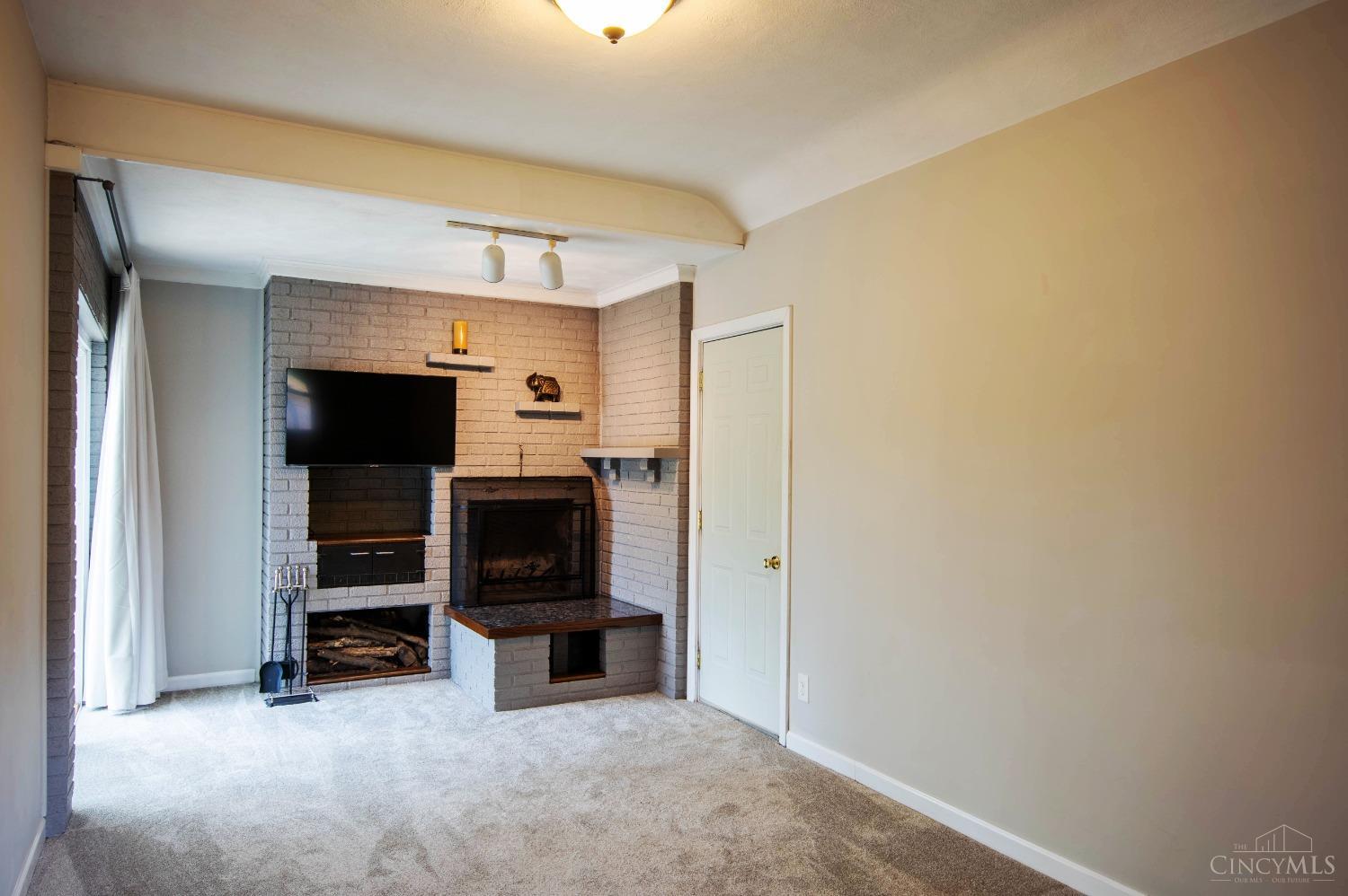 1385 Hunter Road Fairfield, OH 45014 - Photo 15 of 40 TV room with brick wood burning fireplace and wall to wall carpet.