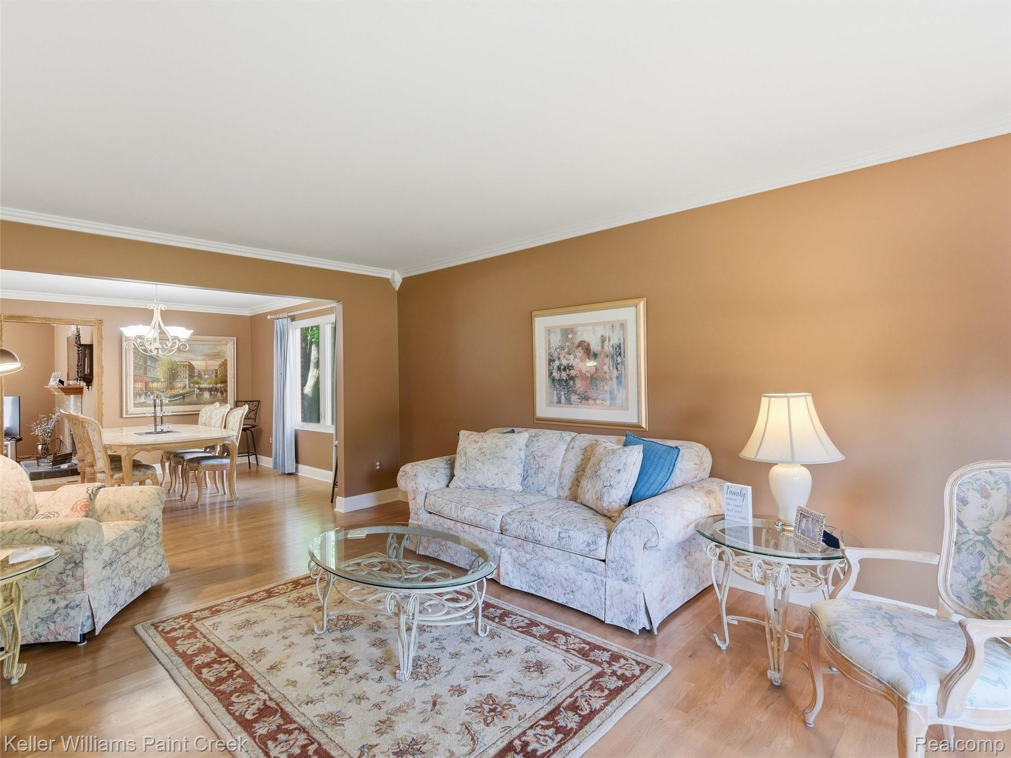 2842 Manorwood Road Troy, MI 48085 - Photo 21 of 72 Living area featuring wood-finish flooring, a cased opening to a separate dining space, crown molding, and a neutral wall color