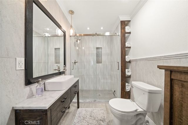 a bathroom with a sink a toilet a mirror and shower