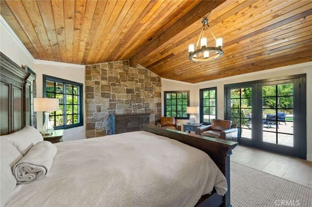 a large bedroom with bed and large windows