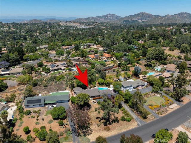 an aerial view of residential houses with outdoor space and trees