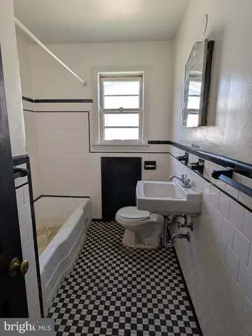 a bathroom with a sink a toilet a window and mirror