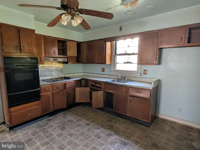 a kitchen with stainless steel appliances granite countertop a sink a stove a refrigerator cabinets and a window