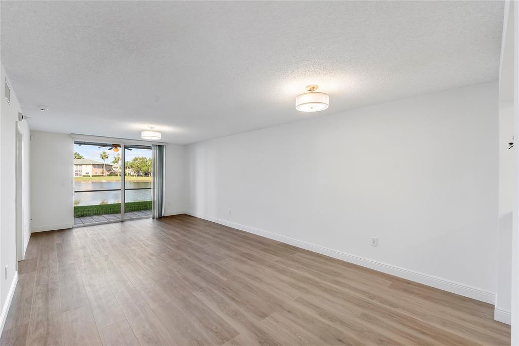 7763 Southampton Terrace, Unit 102 Tamarac, FL 33321 - Photo 25 of 73 a view of an empty room with wooden floor and a window