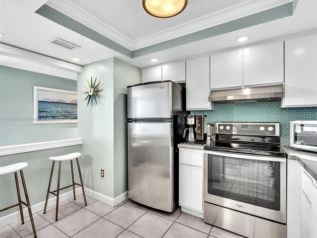 a kitchen with stainless steel appliances granite countertop a refrigerator a stove a sink and a cabinets