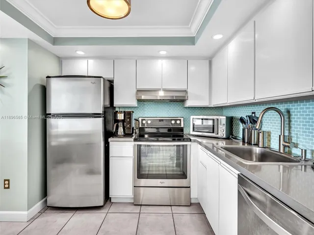 a kitchen with stainless steel appliances granite countertop a refrigerator a stove a sink and a refrigerator