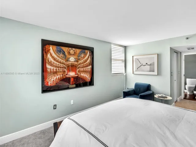a bedroom with a bed and a painting on the wall