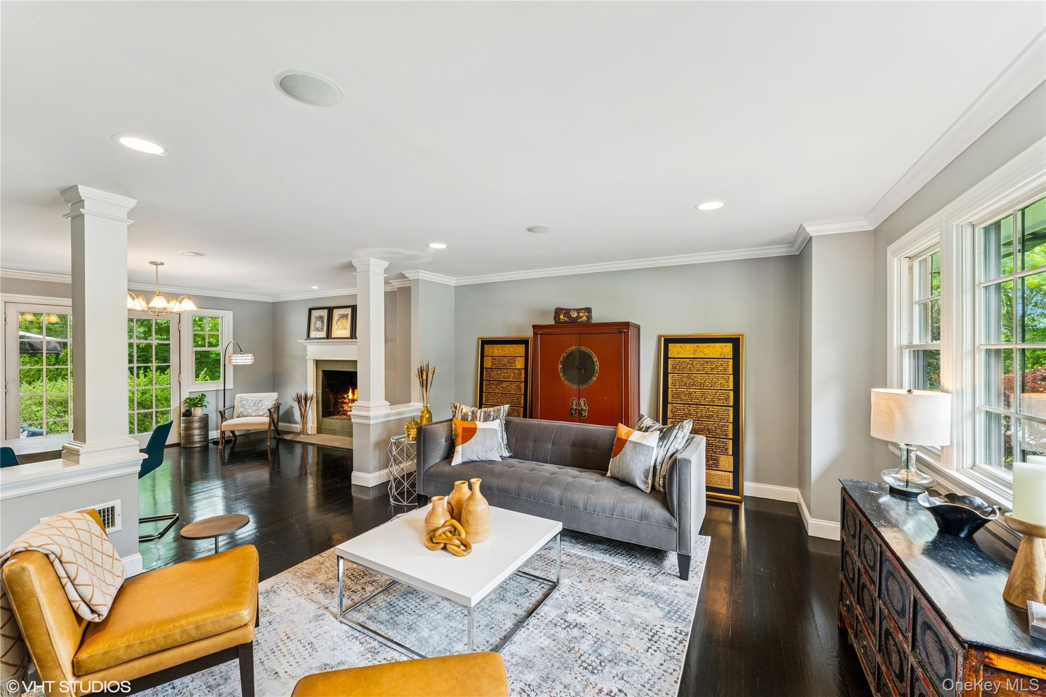 15 Flamingo Road East Hills, NY 11576 - Photo 13 of 41 Living room with healthy amount of natural light, crown molding, dark wood-style flooring, a warm lit fireplace, and recessed lighting