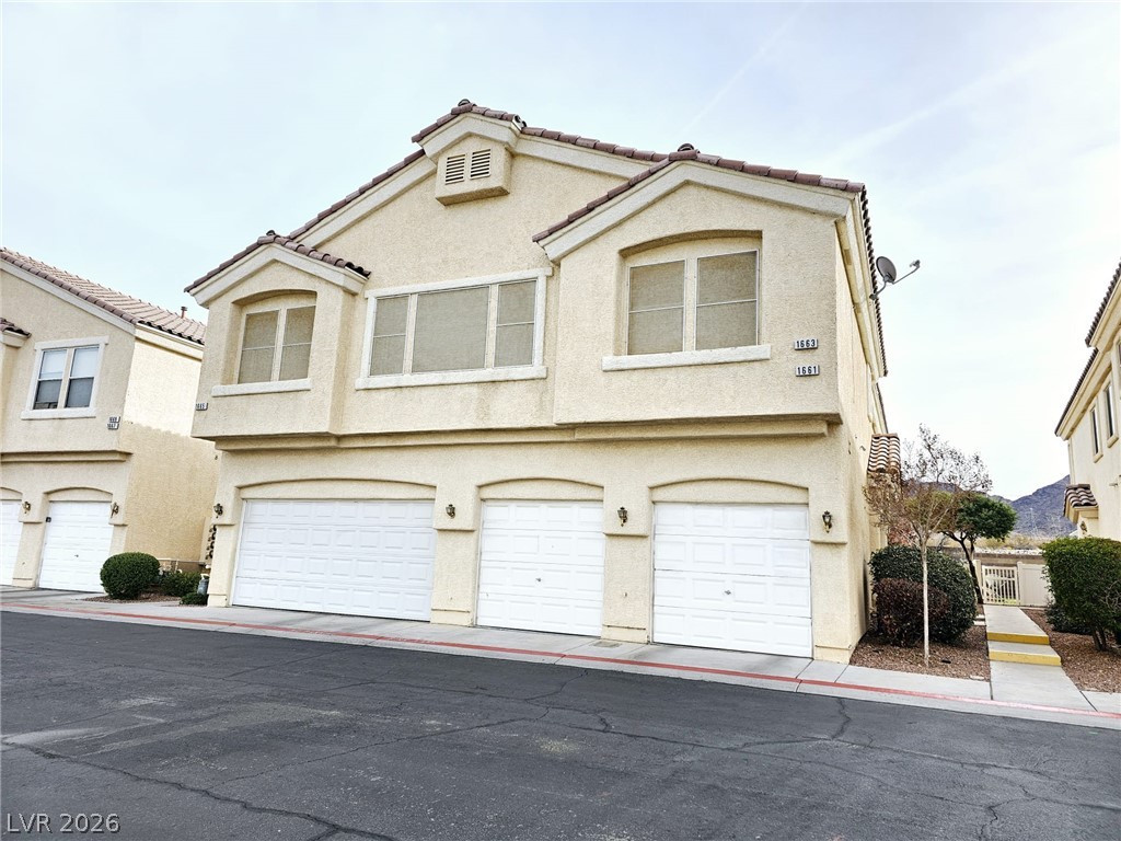 1663 Lefty Garcia Way Henderson, NV 89002 - Photo 28 of 31 Three attached garage doors with archways offer convenient vehicle storage.