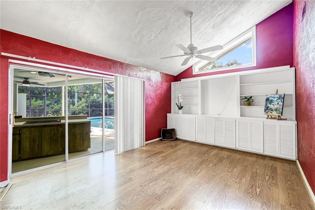 196 Baltusrol Drive Naples, FL 34113 - Photo 9 of 20 Lofted ceiling in this family room with builit in cabinets and book shelves.