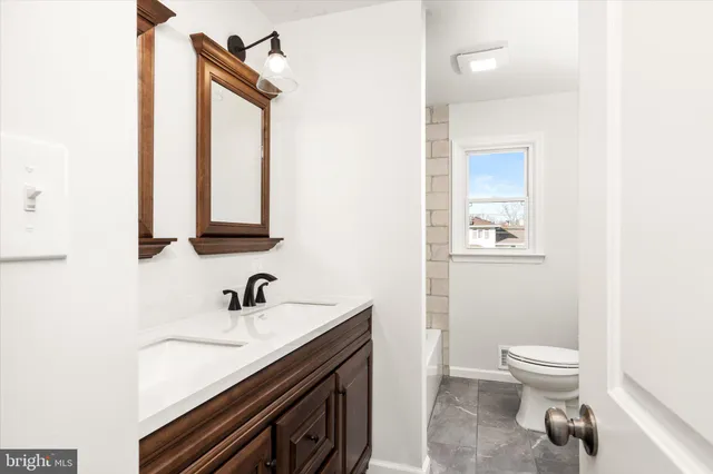 a bathroom with a toilet a sink and mirror