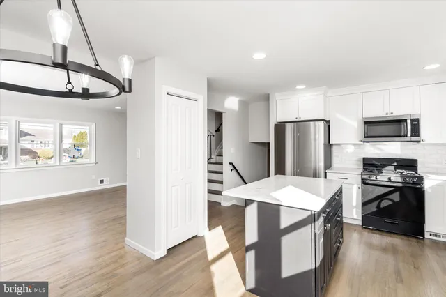a kitchen with a refrigerator a stove top oven a sink and cabinets