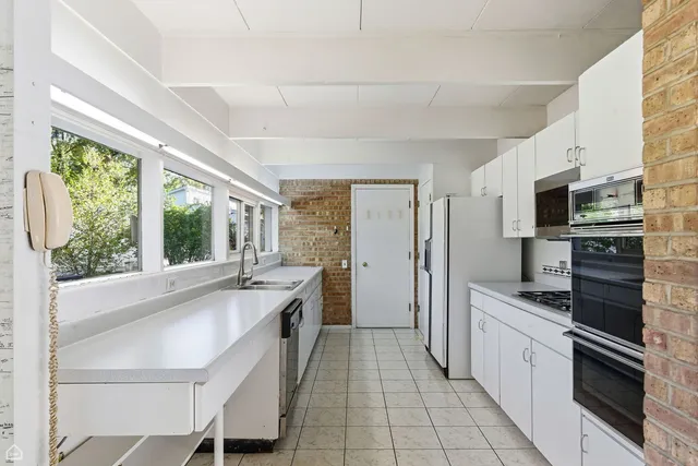 a view of an empty room with wooden floor and windows