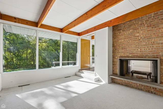 a view of an empty room with a fireplace and a window