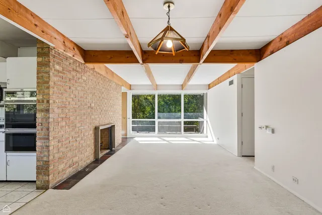 a view of an empty room with a fireplace and a window