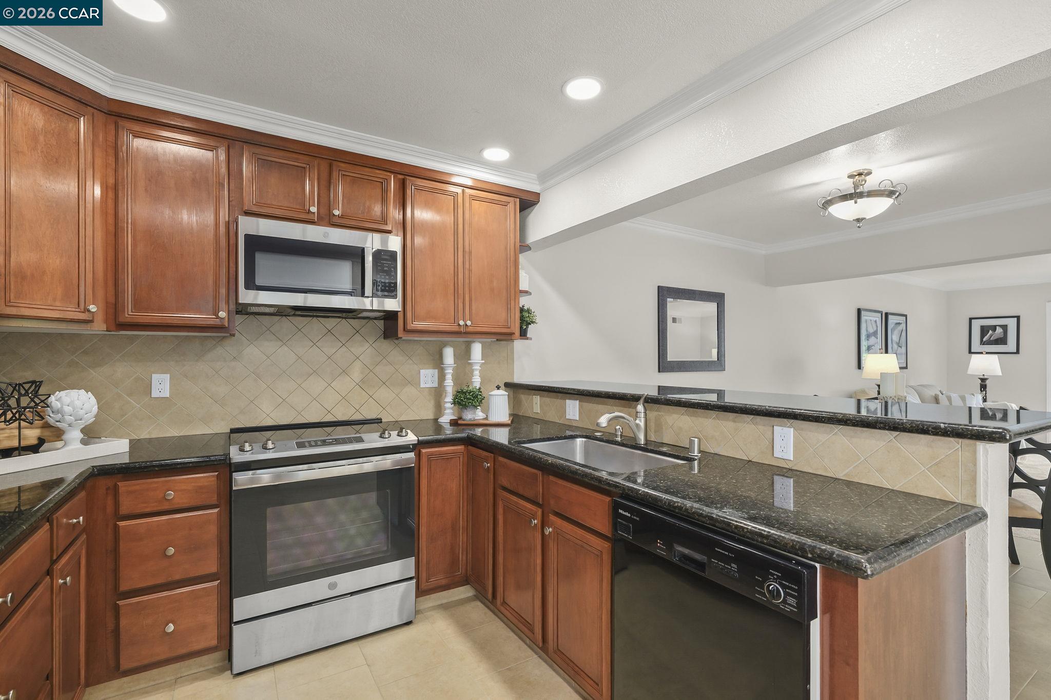 2057 Golden Rain Road, Unit 4 Walnut Creek, CA 94595 - Photo 11 of 20 a kitchen with stainless steel appliances granite countertop a sink stove microwave and cabinets