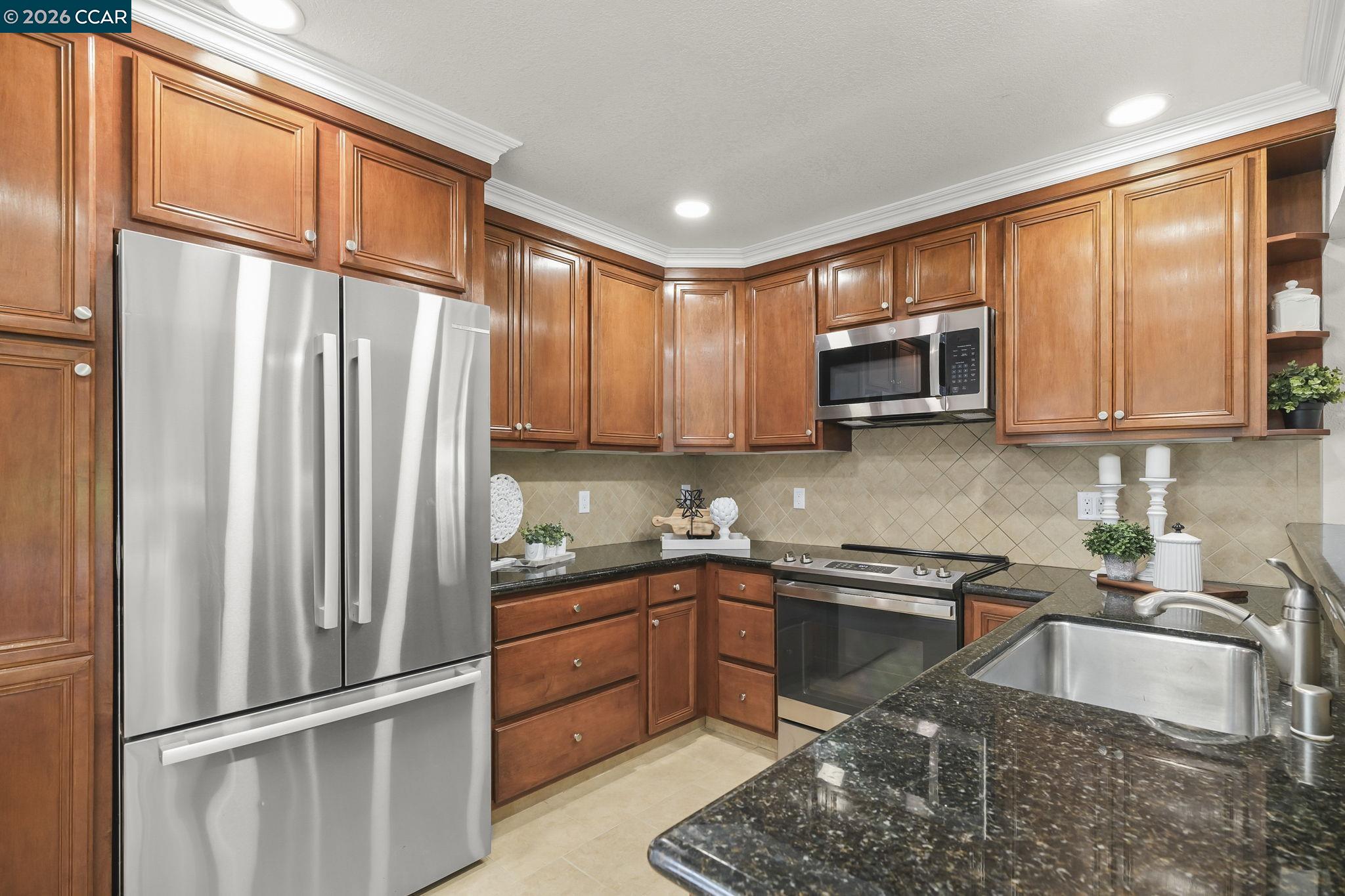 2057 Golden Rain Road, Unit 4 Walnut Creek, CA 94595 - Photo 10 of 20 a kitchen with stainless steel appliances granite countertop a refrigerator sink and microwave