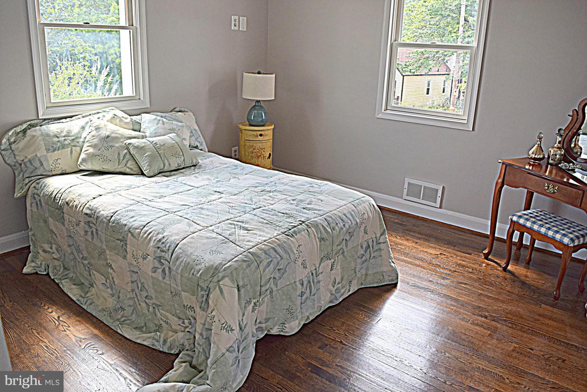8127 Dalesford Road Baltimore, MD 21234 - Photo 14 of 30 a bedroom with a bed and wooden floor