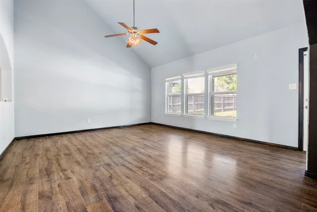 a view of empty room with wooden floor