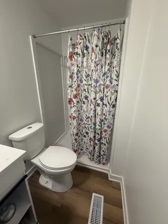 a white toilet sitting next to a shower curtain