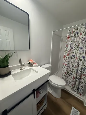 a large kitchen with cabinets wooden floor and stainless steel appliances