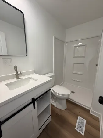 a bathroom with a toilet a sink a mirror and vanity