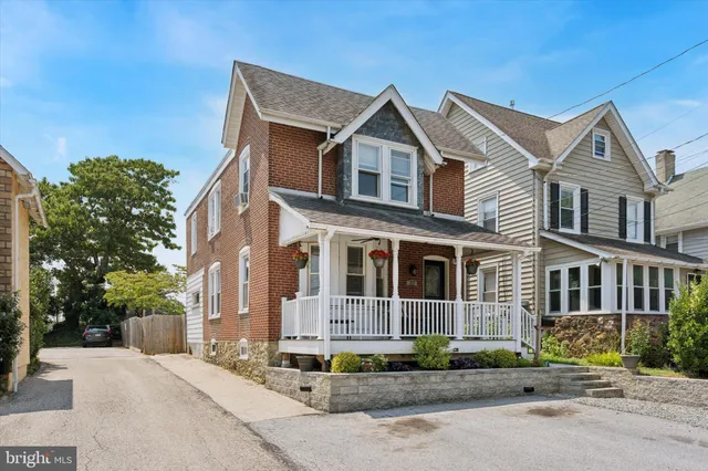 a view of a white house with a yard and plants