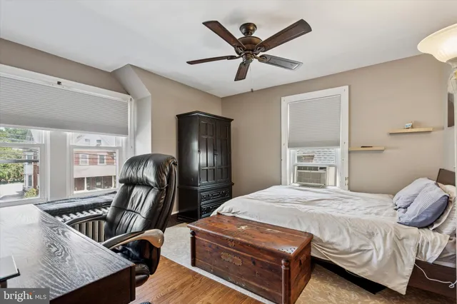 a bedroom with a bed wooden floor and window