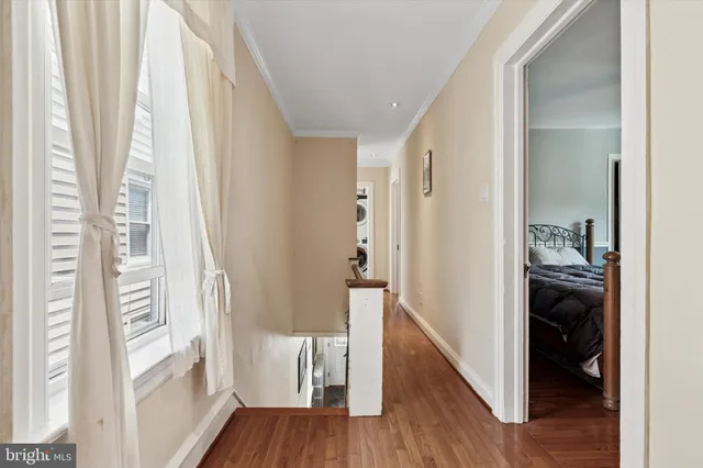 a view of a hallway with wooden floor and furniture