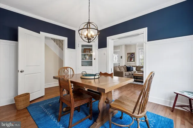a dining room with furniture a chandelier and wooden floor