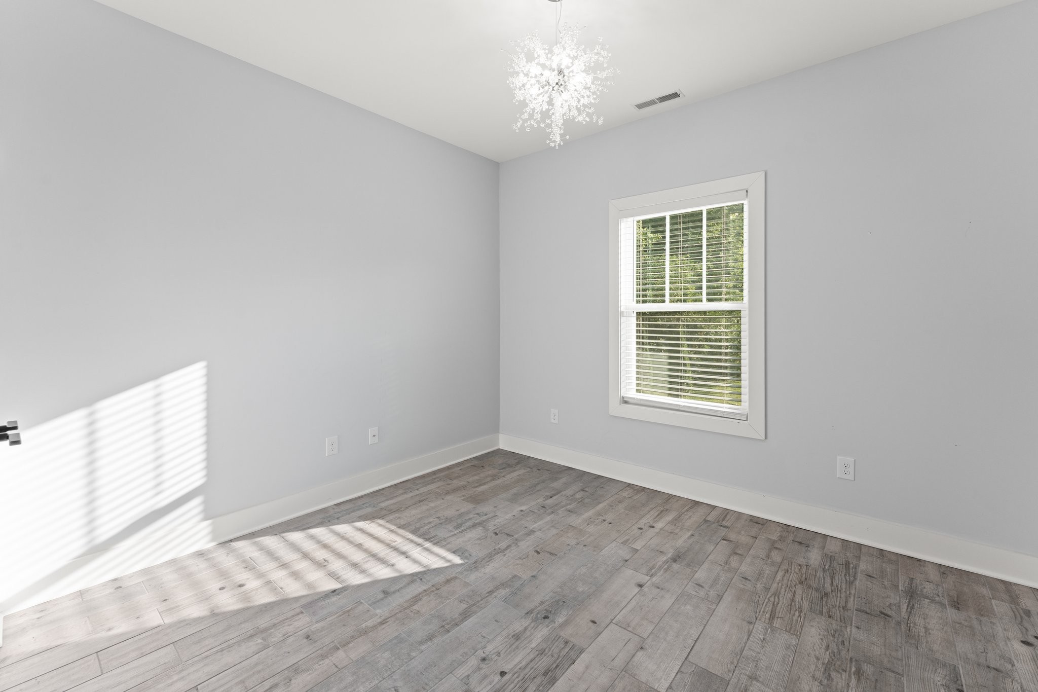 1295 Old Estill Springs Road Winchester, TN 37398 - Photo 22 of 34 an empty room with wooden floor and windows