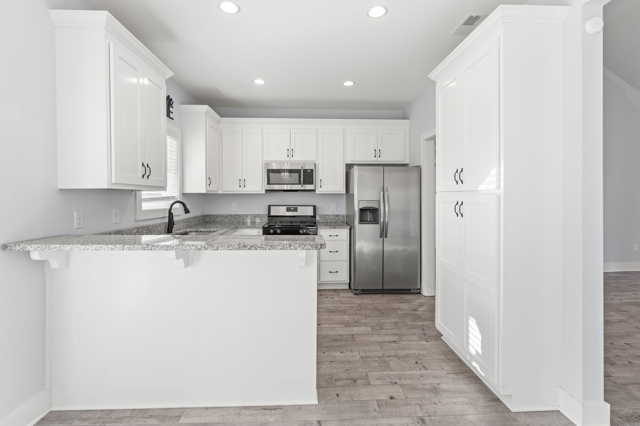 1295 Old Estill Springs Road Winchester, TN 37398 - Photo 10 of 34 a kitchen with kitchen island a refrigerator a sink and white cabinets