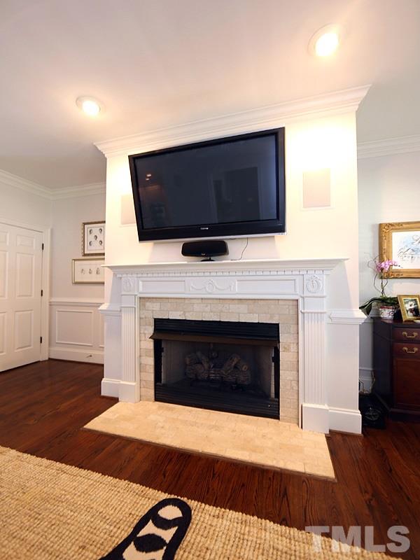 2805 Rothgeb Drive Raleigh, NC 27609 - Photo 10 of 25 a living room with a fireplace a flat screen tv and a fireplace