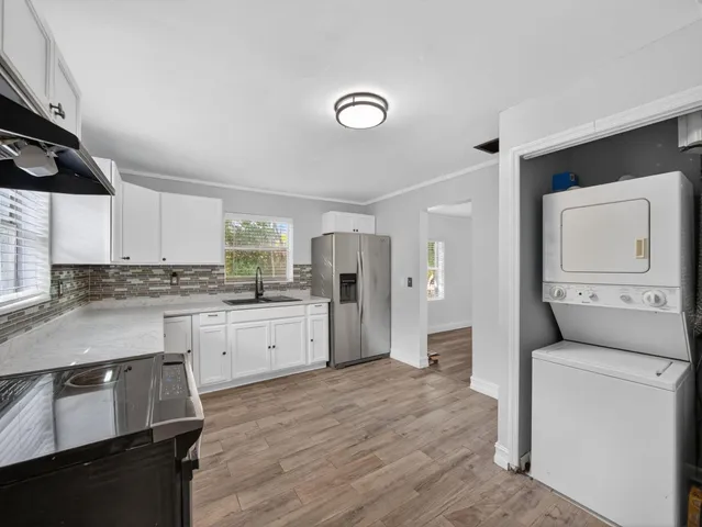 a kitchen with granite countertop white cabinets and refrigerator