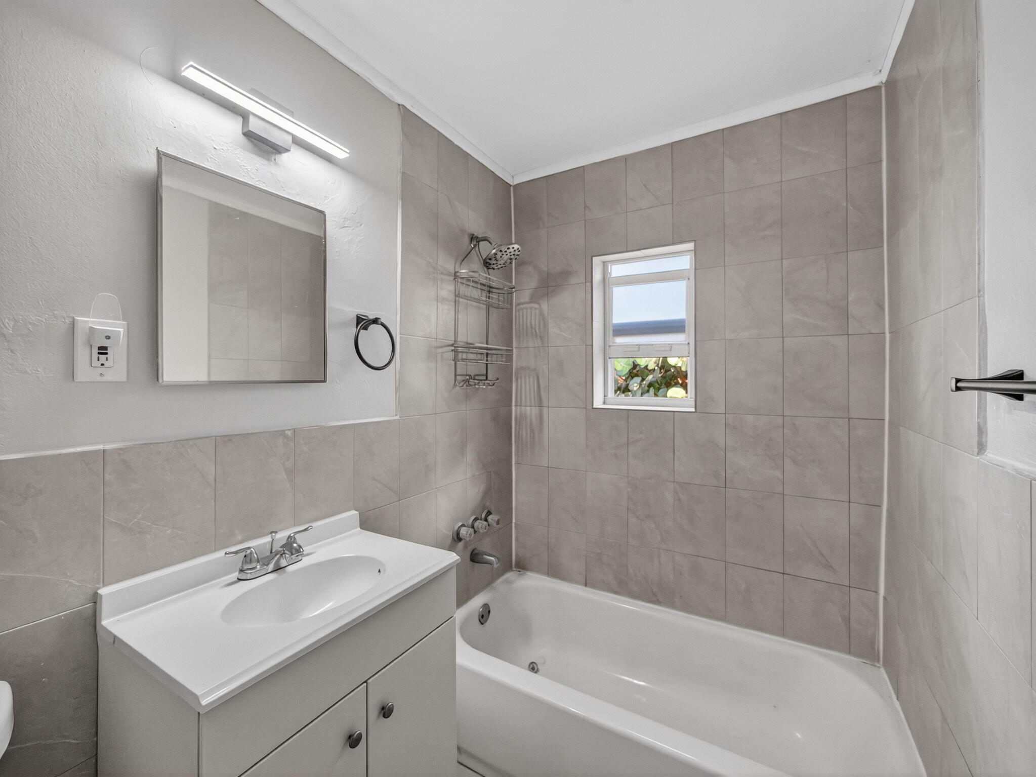 1373 West 35th Street Riviera Beach, FL 33404 - Photo 19 of 20 a bathroom with a sink mirror and a bathtub