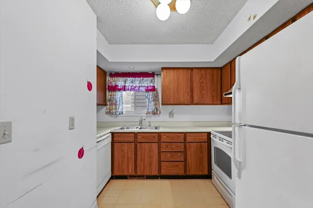 a kitchen with a sink cabinets and a window