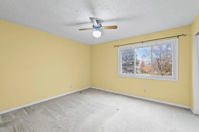 a view of a big room with a ceiling fan and window
