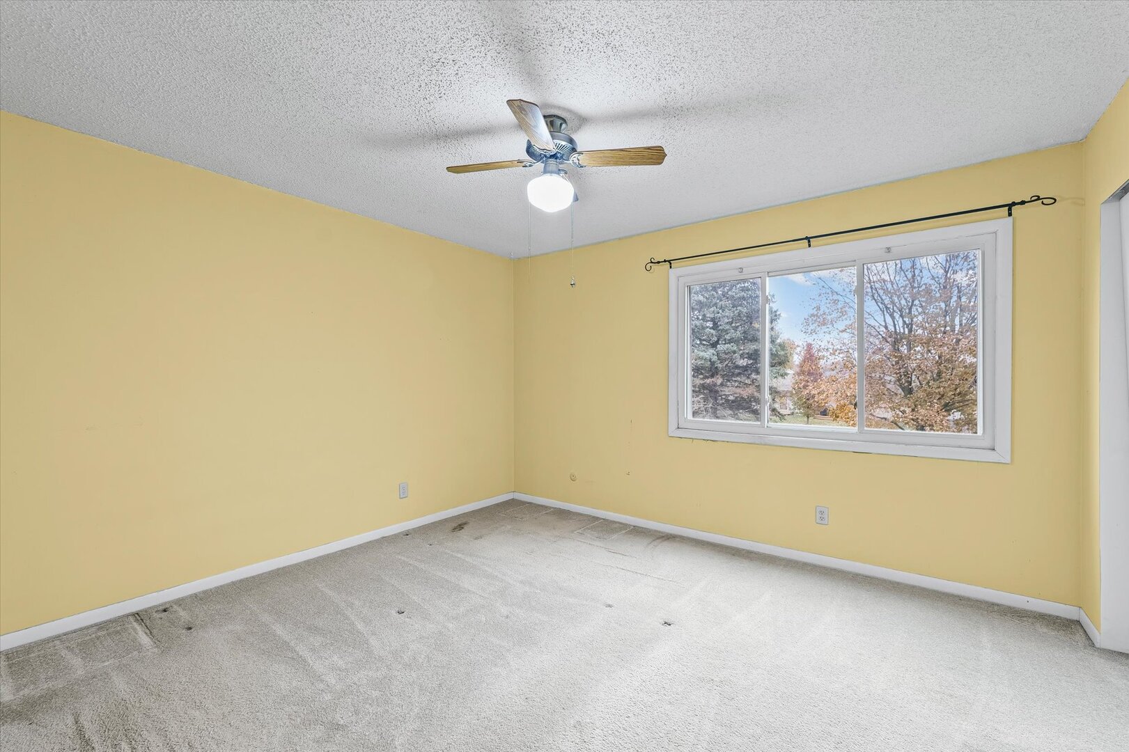 1928 Blackthorn Drive, Unit 1 Champaign, IL 61821 - Photo 17 of 28 a view of a big room with a ceiling fan and window