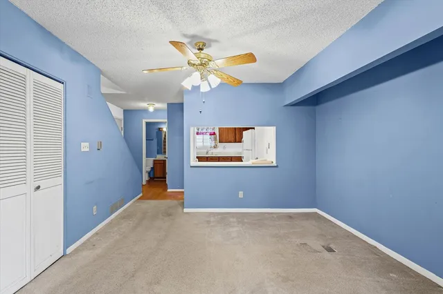 a view of a livingroom with a ceiling fan and window