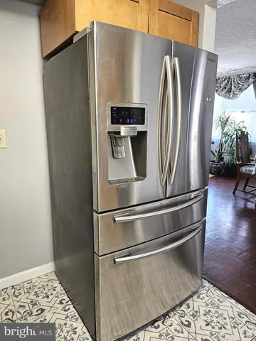 a metallic refrigerator freezer sitting in a kitchen