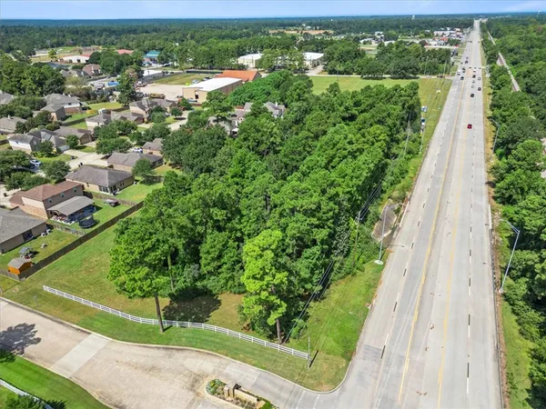 an aerial view of residential houses with outdoor space and trees