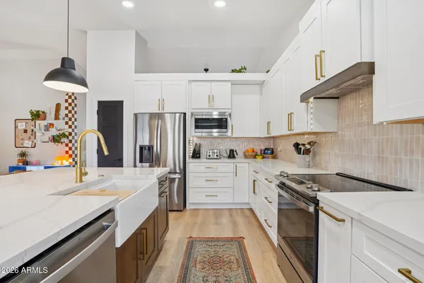 a kitchen with granite countertop a sink stove and refrigerator