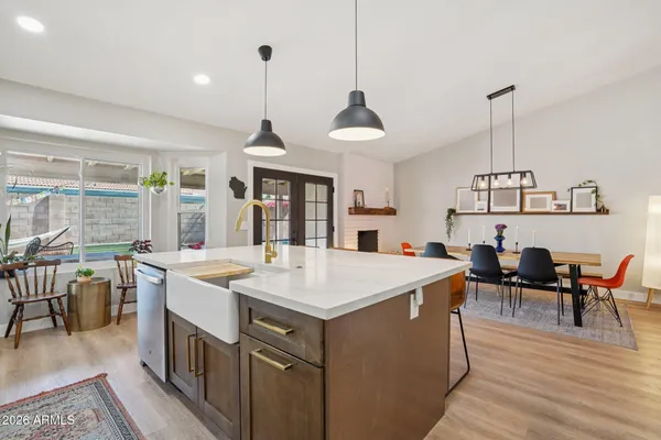 a view of a dining room and livingroom with furniture wooden floor a chandelier