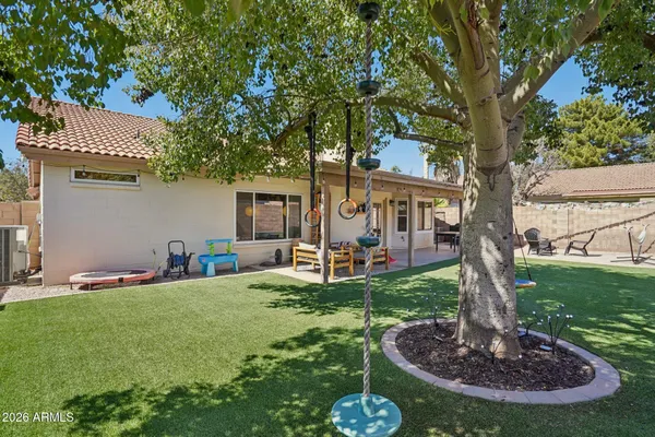 a front view of a house with garden and trees
