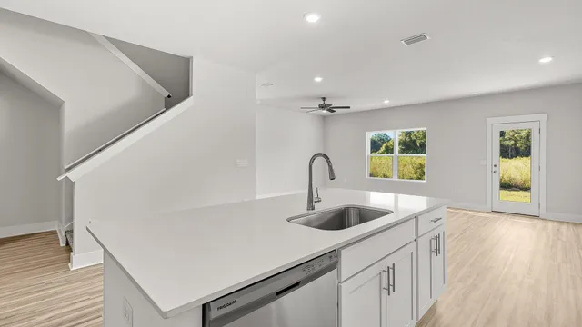 a view of an empty room with kitchen appliances and a window