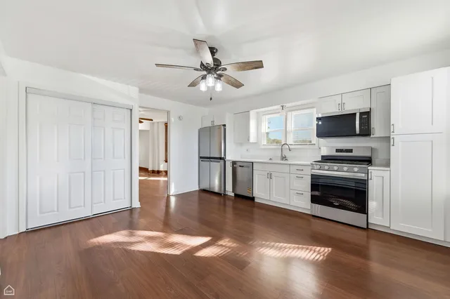 a kitchen with granite countertop a stove top oven and cabinets