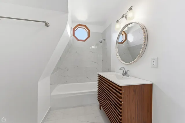 a bathroom with a sink a bathtub and a mirror